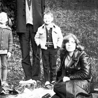 Family group posing outdoors in natural setting.