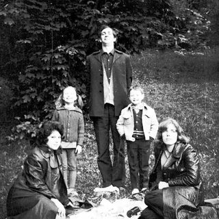 Family group posing outdoors in natural setting.