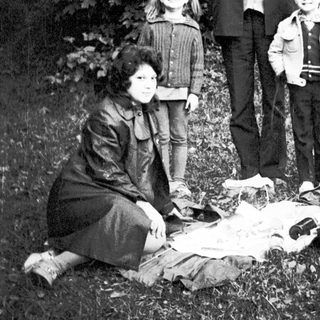 Family group posing outdoors in natural setting.