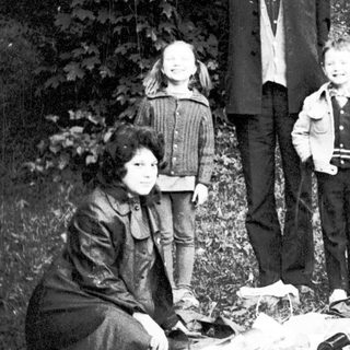 Family group posing outdoors in natural setting.