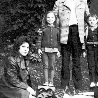 Family group photo outdoors near campfire.