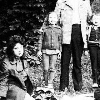 Family group posing outdoors in nature.