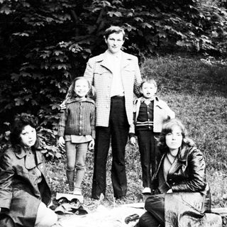 Family group posing outdoors in nature.