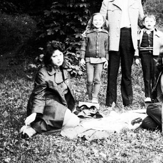 Family group posing outdoors in nature.