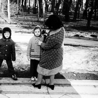 Three people posing outdoors in winter attire.
