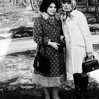 Two women posing together outdoors in winter attire.