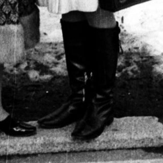 Two women posing closely outdoors in winter attire.