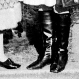 Two women conversing outdoors in winter attire.