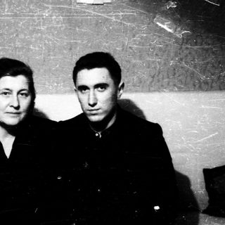 Two individuals posing indoors, mid-20th century style.