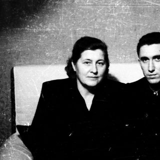 Two individuals posing indoors, mid-20th century style.