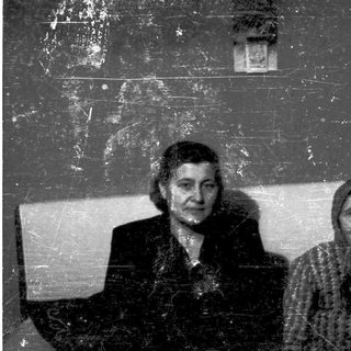 Two elderly women posing indoors, likely from mid-20th century.