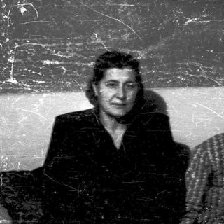 Two elderly women posing indoors together.