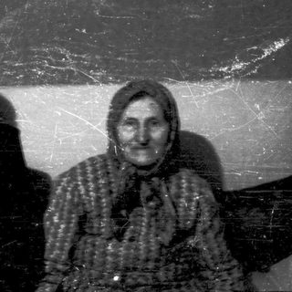 Two elderly women posing indoors together.