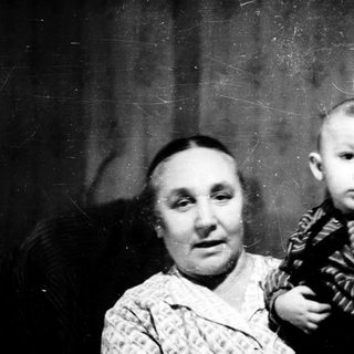 A woman holding a young child in a vintage photograph.