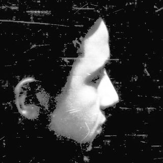 Silhouette of person against textured wall.
