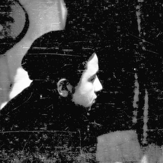 Silhouette of person against textured wall.
