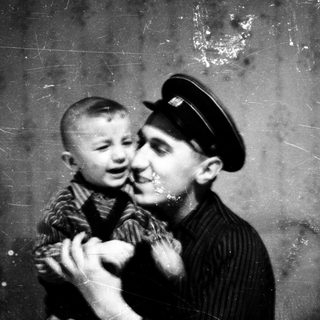 Tender moment between adult and young child indoors.