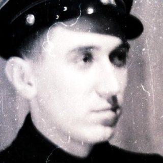 Young man in vintage uniform cap and coat.