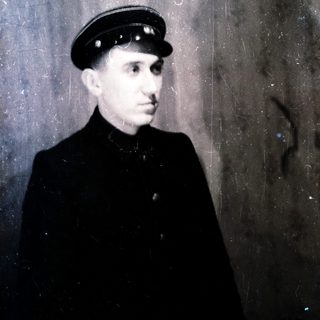 Young man in vintage uniform cap and coat.