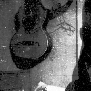 Vintage photo of person playing guitar indoors.