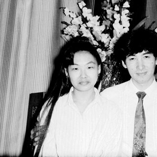 Two individuals posing formally indoors, likely at an event.