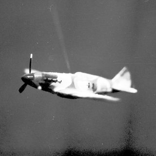 Propeller aircraft in mid-flight, blurred.