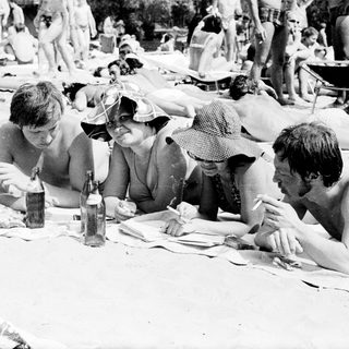 People relaxing and socializing at a beach picnic.
