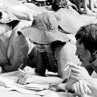 People relaxing and socializing at a beach picnic.