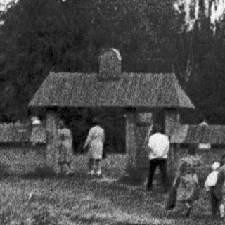 Traditional wooden church with people walking towards it.