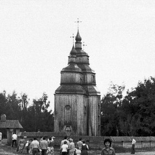 Traditional wooden church with people walking towards it.
