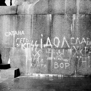 Graffiti in Cyrillic script on stone wall.