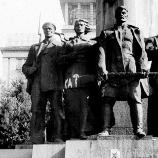 Statue defaced with graffiti, depicting Soviet leaders.