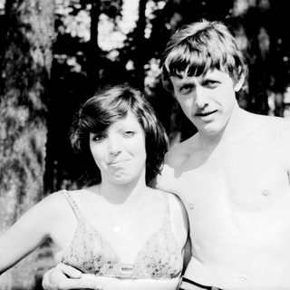 Two people posing outdoors in summer attire.