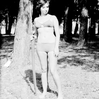 Young woman posing outdoors in vintage swimsuit.