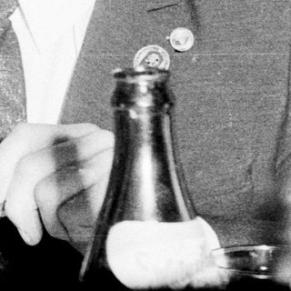 Two men in suits toasting with glasses.