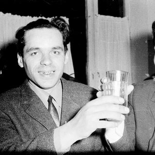 Two men in suits toasting with glasses.