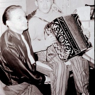 Two men playing accordion indoors together.
