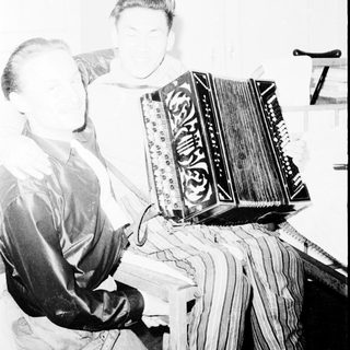 Person playing large accordion indoors.