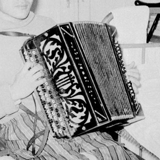 Man playing vintage accordion indoors.