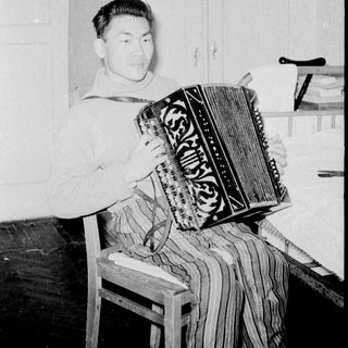 Man playing vintage accordion indoors.