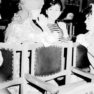 Costumed women and girl in vintage church pews.