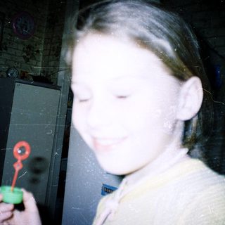 Child holding a toy keychain indoors.