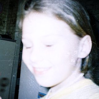 Child holding a toy keychain indoors.