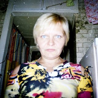 Woman standing in doorway with floral top.