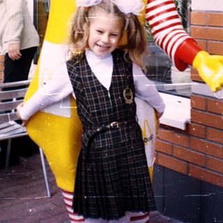 Ronald McDonald posing with a young girl.
