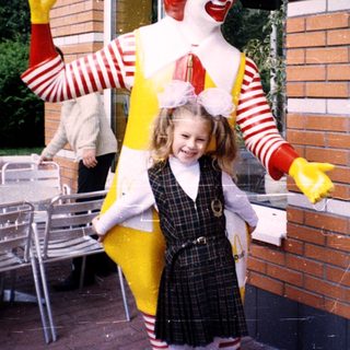 Ronald McDonald posing with a young girl.