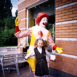 Ronald McDonald posing with a young girl.