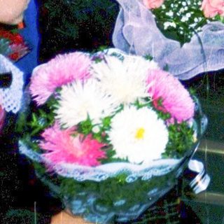 First-day-of-school celebration with students in formal attire holding flowers.