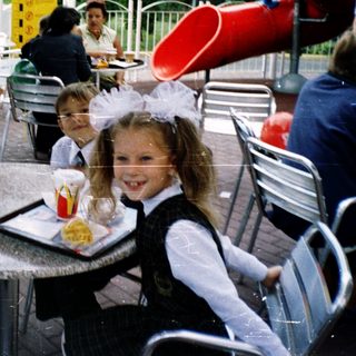 Children in school uniforms eating outdoors at McDonald's.