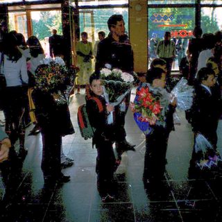 First-day-of-school gathering with students holding flowers.